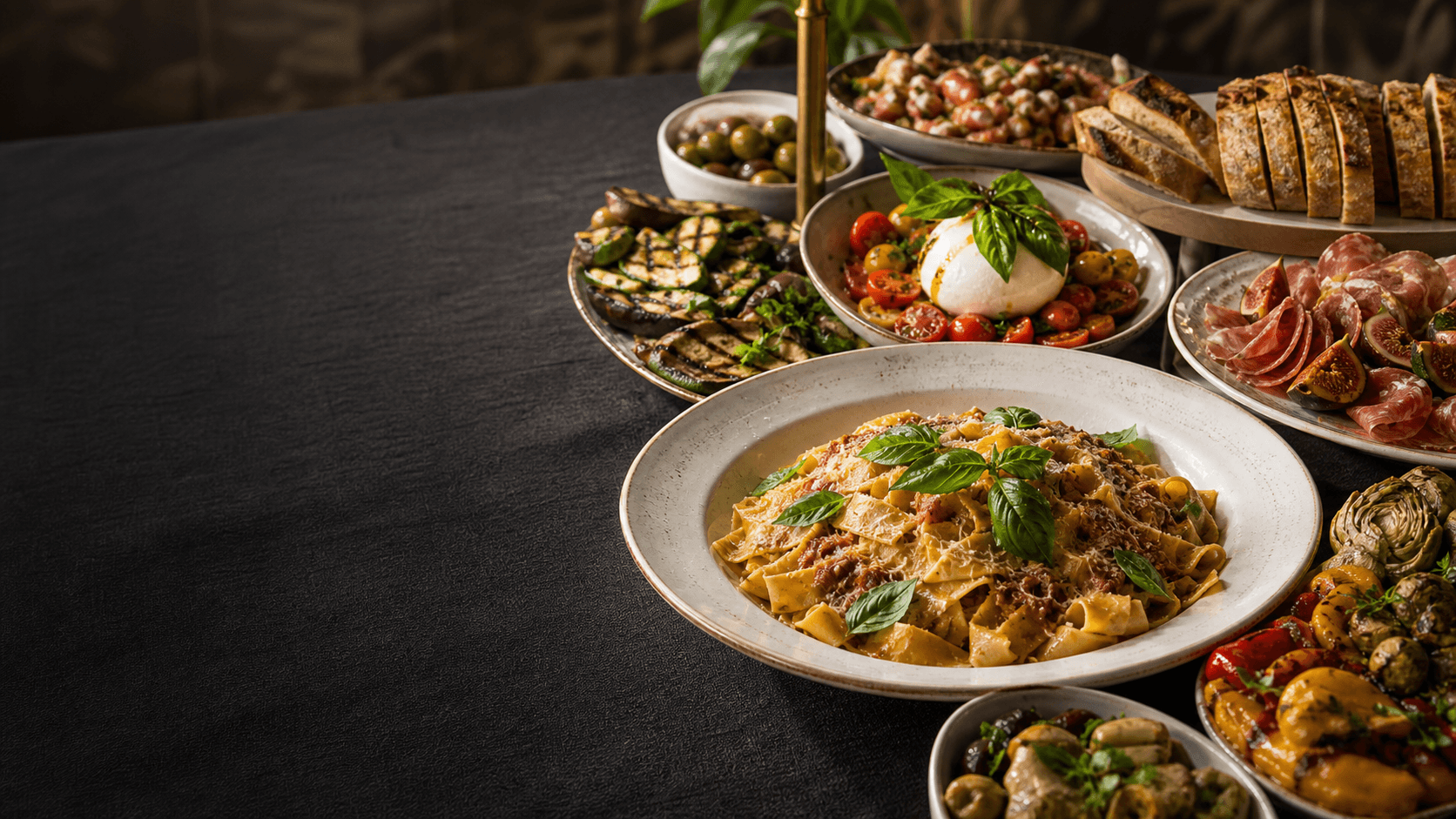 Italian catering spread with pasta, burrata, vegetables and antipasti